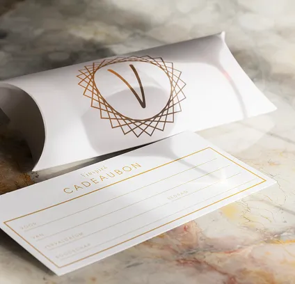 Vinspire cadeaubon: het ideale geschenk. Luxe witte cadeaubon en geschenkverpakking met Vinspire logo op een lichte marmeren ondergrond.