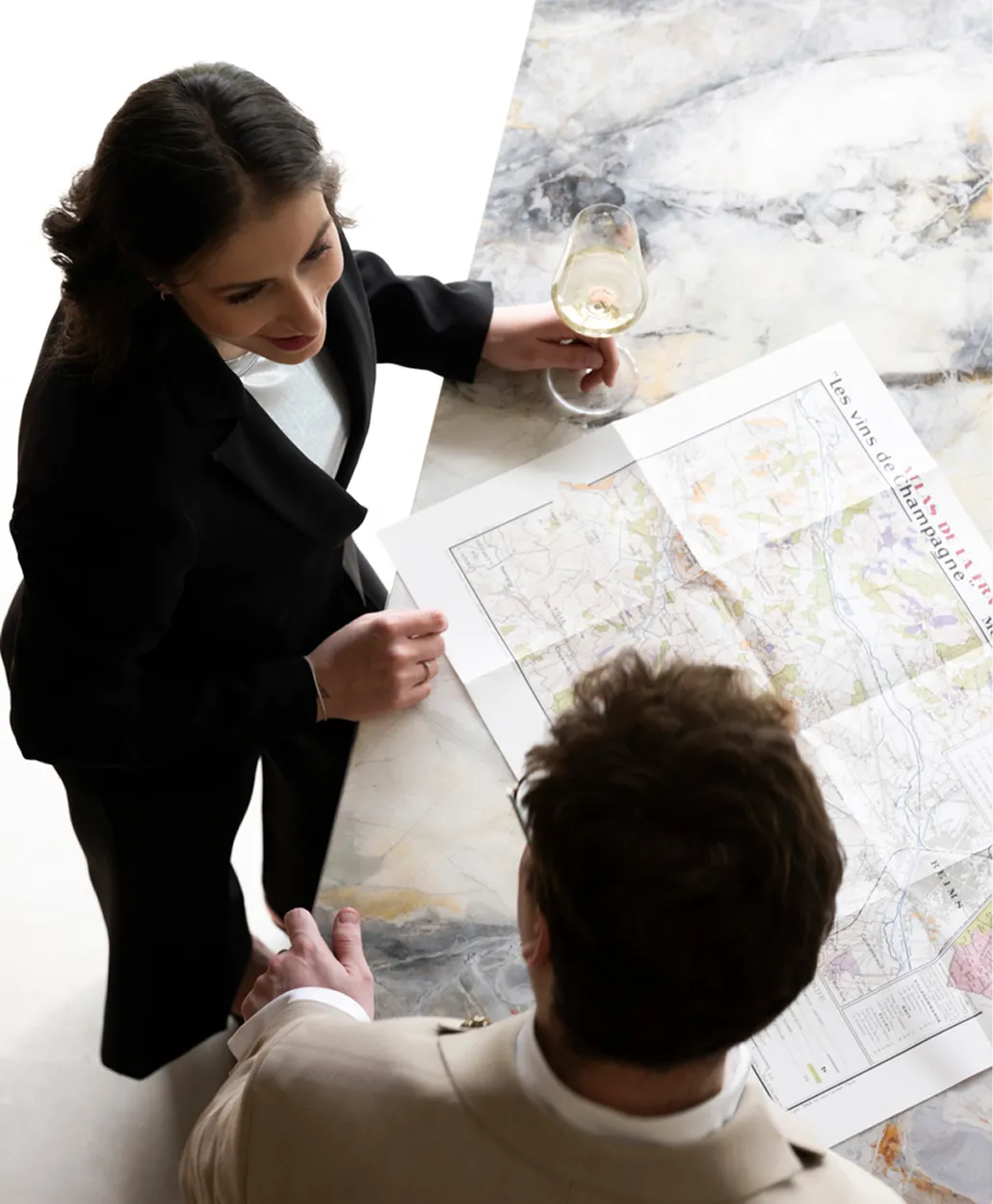 Persoonlijk wijnadvies van jouw sommelier Een sommelier en klant bestuderen een wijnkaart van champagneregio's, met een glas witte wijn.