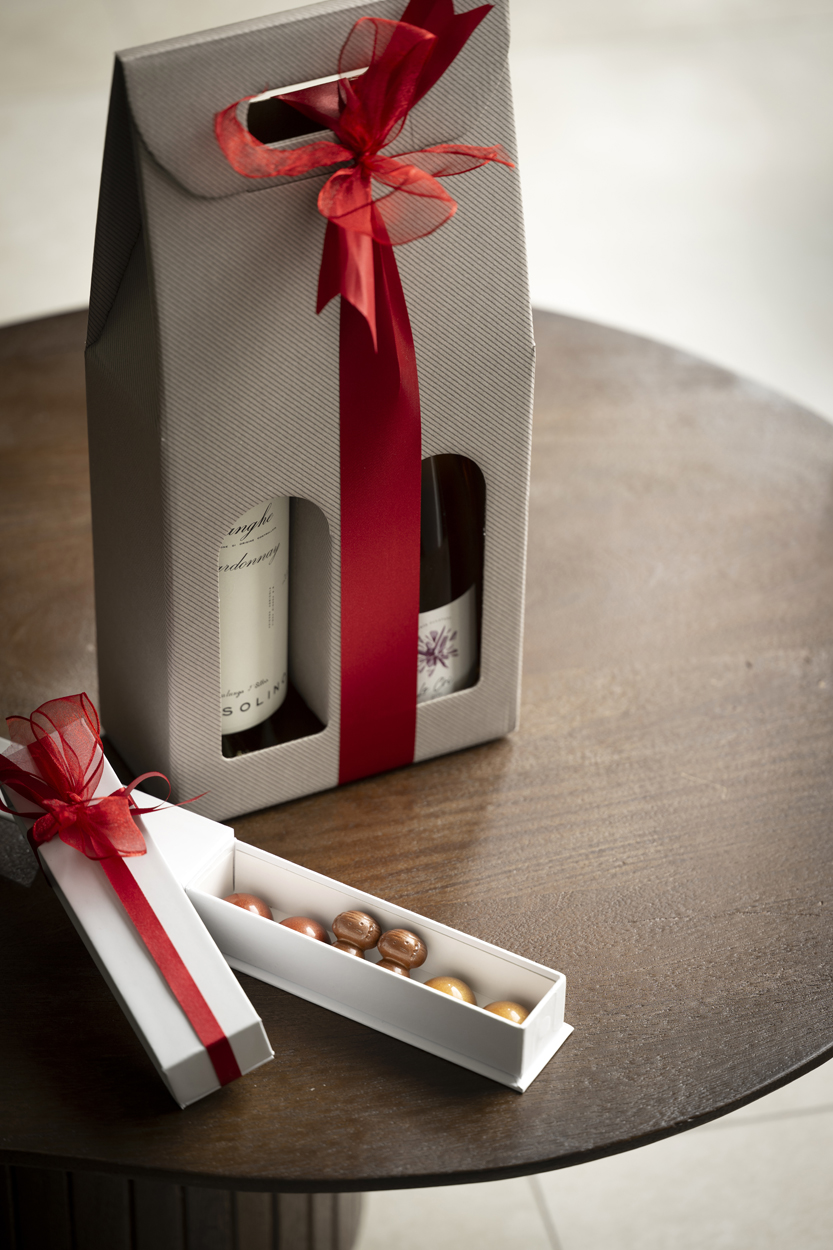 VINSPIRE_Wijn&Patisserie Vier flessen rode kwaliteitswijn staan op een glanzend marmeren oppervlak, klaar voor een wijnproeverij.
