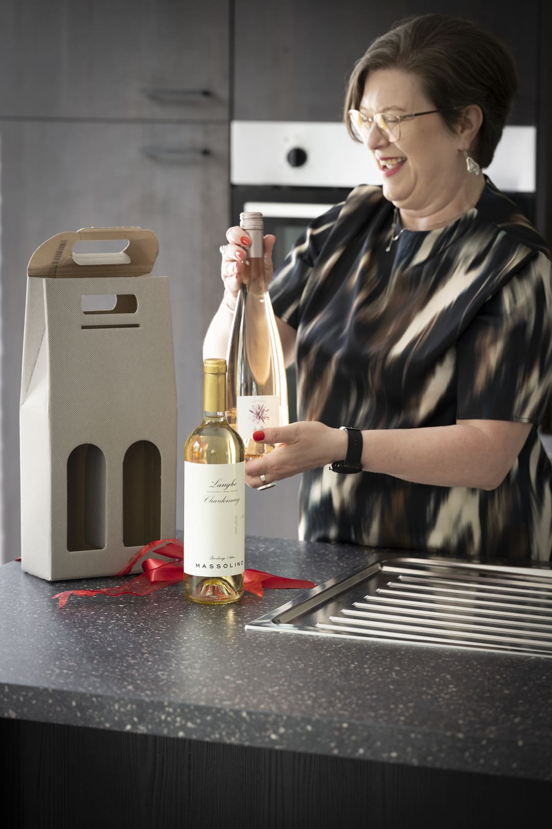 wijncadeau-luxe-verpakking-vinspire Witte cadeaubon van Vinspiré met gouden details en een bijpassende geschenkverpakking op marmeren ondergrond.